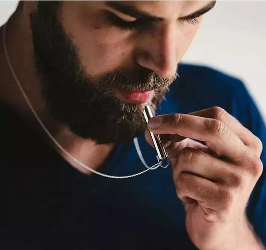 Persona usando el collar silbato Anti Anxiety Mindful, demostrando su uso para aliviar la ansiedad.